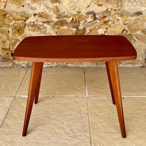 Può includere: Tavolino in stile moderno della metà del secolo, con piano rettangolare e gambe angolate. Il tavolo è in legno con finitura marrone rossiccio. Il tavolo misura circa 61 cm di lunghezza, 41 cm di larghezza e 46 cm di altezza.