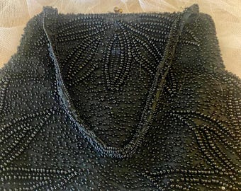 Bolsa de noite vintage preta, ricamente bordada com miçangas, forro de cetim e alça também bordada com miçangas.