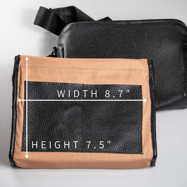 May include: A black textured crossbody bag with a tan interior lining. The bag features a rectangular front pocket with a black leather-like finish. White text indicates a width of 8.7 inches and a height of 7.5 inches with directional arrows.