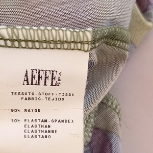 May include: A white fabric care label with the text "AEFFE" and the fabric composition: 90% rayon and 10% elastam-spandex, elasthan, elasthanne, elastano. The label also includes the code GA04570744.