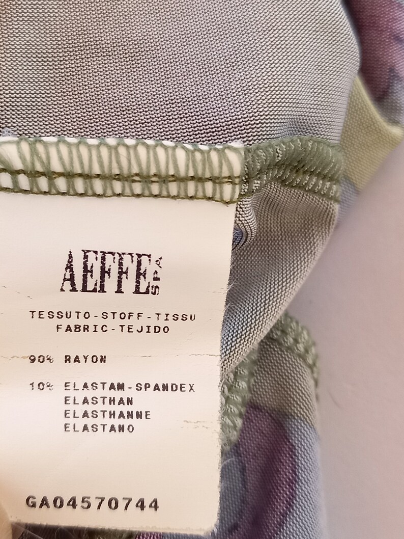 May include: A white fabric care label with the text "AEFFE" and the fabric composition: 90% rayon and 10% elastam-spandex, elasthan, elasthanne, elastano. The label also includes the code GA04570744.