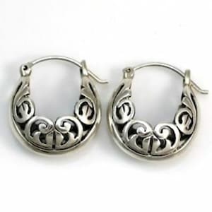 May include: A pair of silver hoop earrings with a delicate, intricate floral design. The earrings are made of metal and have a polished finish.