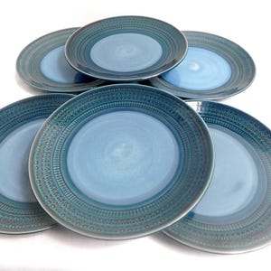 May include: A set of three ceramic mugs with a speckled, matte finish. The mugs are in shades of cream, light brown, and dark brown. Each mug has a simple, minimalist design, perfect for coffee or tea.