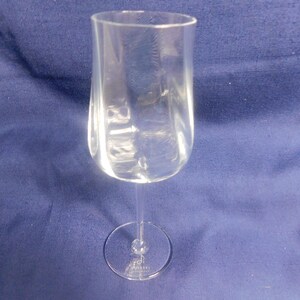 May include: A clear wine glass with a rounded bowl and a slender stem. The glass is made of transparent material. The base is a small, circular foot. The glass is designed for serving wine.