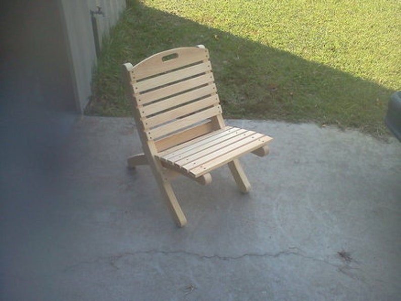 May include: A wooden folding chair with a natural finish. The chair has a slatted back and seat.