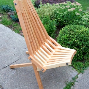 May include: A wooden folding chair with a slatted back and seat. The chair is made of natural wood and has a simple, rustic design.