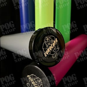 May include: A collection of colorful, cylindrical containers with black caps. The caps feature a gold logo with the text "EUROCAPS" and a cartoon bear. The containers are in various colors, including gray, pink, green, and blue.