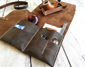 May include: A brown leather pipe carrying case with multiple pockets and a separate pouch for a pipe. The case is open and shows a pipe, a lighter, and a cleaning tool.
