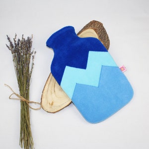 Könnte beinhalten: Blaue und hellblaue Hot Water Bottle mit Chevron-Muster und weicher, flauschiger Textur.