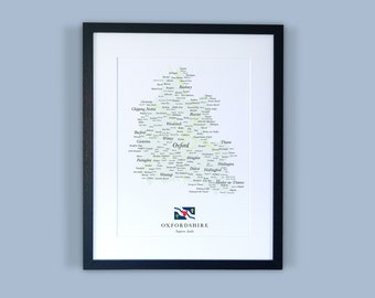 Może przedstawiać: Wydrukowana mapa hrabstwa Oxfordshire w Anglii, oprawiona w ramę. Mapa przedstawia stylizowane drzewo, na którego gałęziach znajdują się nazwy miast i wsi w hrabstwie. W prawym dolnym rogu znajduje się flaga Oxfordshire.