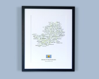 Könnte beinhalten: Ein gerahmter Druck einer Karte von Hertfordshire, England, mit den Namen der Städte und Gemeinden in einer wolkenartigen Formation aufgelistet. Die Karte ist in Schwarzweiß mit einer gelben Umrandung. Der Text "Hertfordshire" ist unter der Karte gedruckt, zusammen mit dem Motto "Trust and Fear Not".