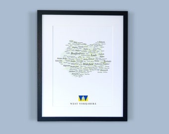 Könnte beinhalten: Ein gerahmter Druck einer Wortwolkenkarte von West Yorkshire, England. Die Karte besteht aus den Namen der Städte und Gemeinden der Region, wobei die größten Städte, Leeds und Bradford, in der Mitte erscheinen. Der Druck ist in Schwarz gerahmt und zeigt unten rechts eine kleine Flagge von West Yorkshire.