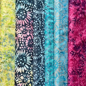 May include: Five fabric swatches with a batik pattern of white circles on a dark background. The colours of the fabrics are green, pink, blue, teal, and purple.