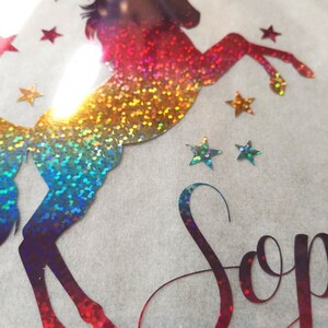 May include: A rainbow iridescent glitter unicorn silhouette with stars and the name "Sophia" in a glittery font.
