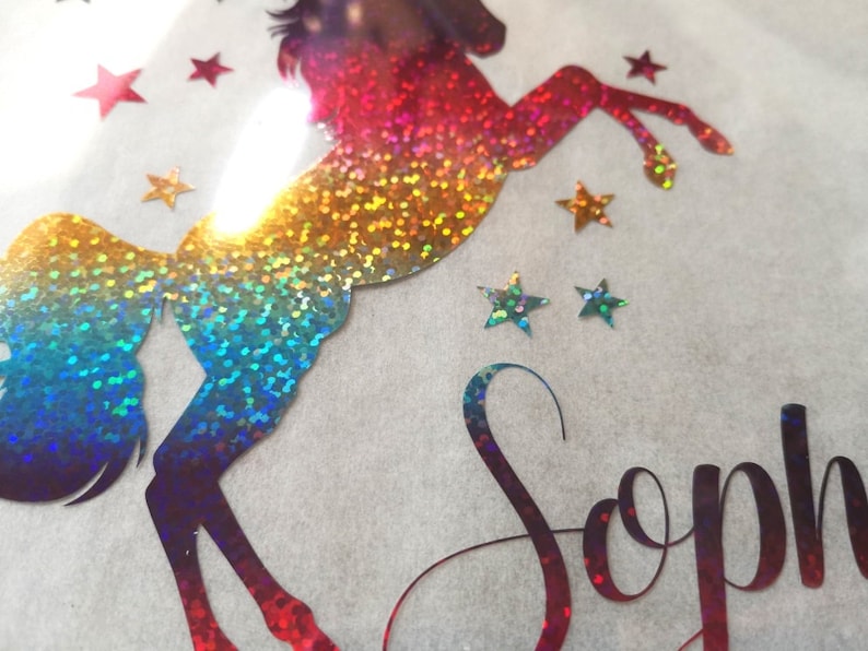 May include: A rainbow iridescent glitter unicorn silhouette with stars and the name "Sophia" in a glittery font.