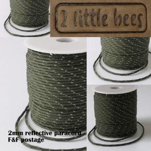 May include: A spool of 2mm reflective paracord in a green and white camouflage pattern. The spool is labeled "2 little bees" and "2mm reflective paracord F&F postage".