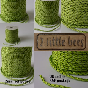 May include: A spool of 2 mm reflective lime green cord with black accents. The cord is wound around a white cardboard spool. The text "2mm reflective" is printed on the bottom of the image. The text "2 little bees" is printed on a brown label.
