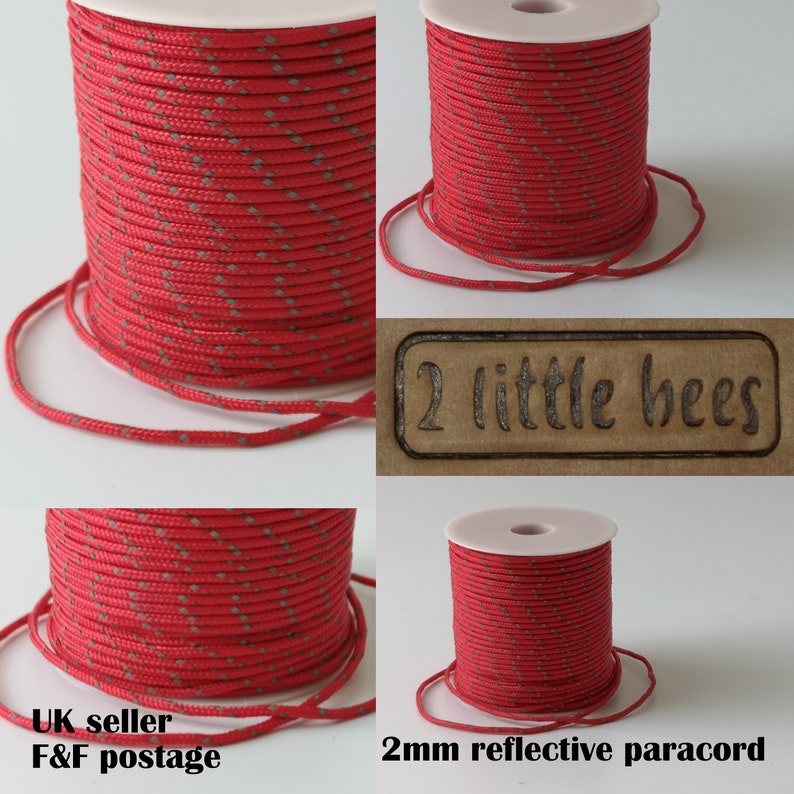 May include: A spool of 2mm red reflective paracord with a white background. The paracord is wound around a white spool with a label that says "2 little bees".