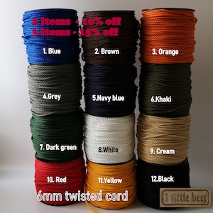 May include: Twelve spools of 6mm twisted cord in a variety of colours, including blue, brown, orange, grey, navy blue, khaki, dark green, white, cream, red, yellow, and black. The spools are arranged in three rows of four. The text "2 items - 10% off" and "3 items - 15% off" is displayed at the top of the image. The text "6mm twisted cord" is displayed at the bottom of the image. The text "2 little bees" is displayed in a small rectangle at the bottom right corner of the image.