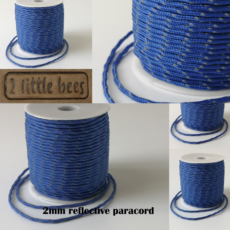 May include: A spool of 2mm reflective paracord in blue with a white reflective thread. The paracord is wound around a white spool and is labeled "2 little bees".