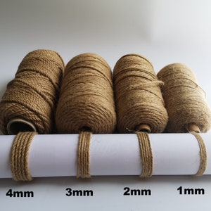 May include: Four spools of natural brown twine, each with a different thickness: 4mm, 3mm, 2mm, and 1mm. The spools are arranged in order of size, with the largest spool on the left and the smallest spool on the right.
