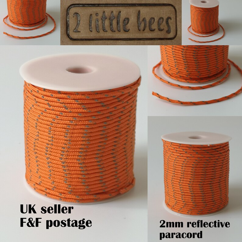 May include: A spool of 2mm reflective orange paracord with grey reflective threads. The paracord is wound around a white plastic spool. The text "2 little bees" is printed on a brown label.