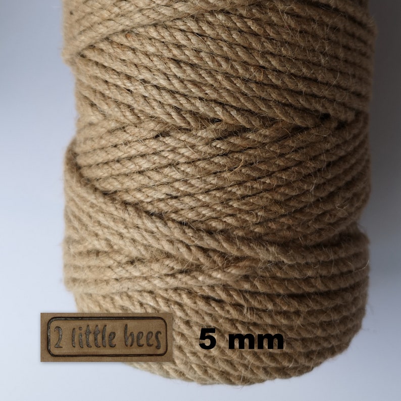 May include: A close-up of a spool of natural brown jute twine. The twine is 5 mm thick and is labeled "2 little bees".