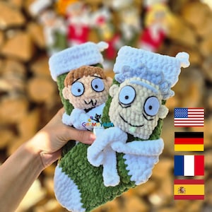 Könnte beinhalten: Zwei grüne und weiße gehäkelte Weihnachtsstrümpfe mit Gesichtern von Zeichentrickfiguren. Ein Strumpf zeigt eine Figur mit braunen Haaren und einem weißen Hemd. Der andere Strumpf hat eine Figur mit blauen Haaren und einem weißen Laborkittel.