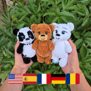 Puede incluir: Tres osos de peluche de ganchillo hechos a mano: un oso panda con pelaje blanco y negro, un oso marrón y un oso blanco. Cada oso tiene rasgos faciales bordados y se sostiene contra un fondo de follaje verde.