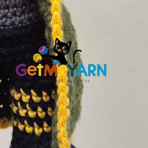 May include: Close-up of a crocheted item in black, olive green, and yellow. The item has a textured appearance with a yellow border. The text "GetMeYARN CROCHET BUSINESS" is visible.