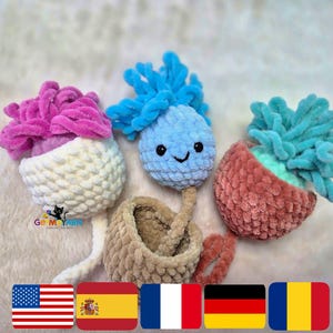 Peut inclure: Une collection de jouets au crochet faits à la main de différentes couleurs. Les jouets comprennent une fleur rose et blanche, un personnage bleu souriant et une plante turquoise et corail. Les jouets sont faits de fil doux et texturé.