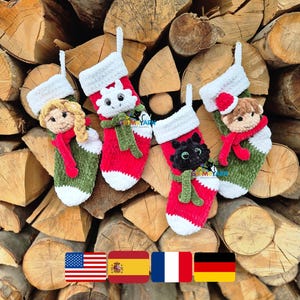 May include: Four handmade Christmas stockings with character faces, including a snowman, a girl, a cat, and a bear. Each stocking is red, white, and green, with a white cuff and a loop for hanging. The stockings are displayed against a backdrop of stacked firewood.