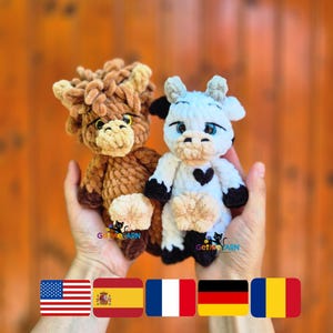 May include: Two handmade crochet cow plushies. One is brown and tan, the other is white and black. Both have cute faces and are held in hands. The text "Get Me YARN" is visible on the bottom of the image.