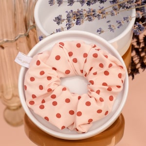 Chouchou with burgundy polka dots on a light pink background