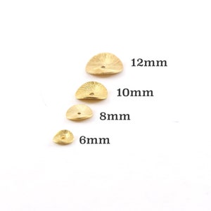 May include: Four gold-colored metal discs with a textured surface and a hole in the center. The discs are arranged in a row from largest to smallest, with the largest disc measuring 12mm, the next largest measuring 10mm, the next measuring 8mm, and the smallest measuring 6mm.