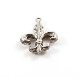 Colgante con dije de flor de lis gruesa y detallada en plata de ley con flor francesa