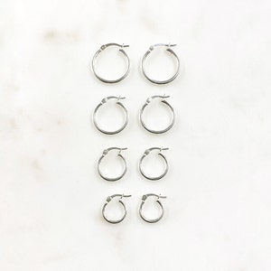 May include: Set of six silver hoop earrings in various sizes. The earrings are arranged in pairs from largest to smallest.