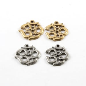 May include: Four metal charms in the shape of the Om symbol. Two charms are gold and two charms are silver.
