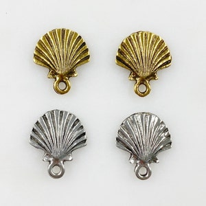 May include: Four metal seashell charms with a loop for hanging. Two are gold and two are silver.