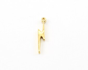May include: A gold-colored lightning bolt charm with a loop at the top for attaching to a necklace or bracelet.