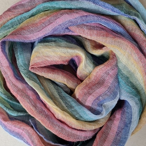 May include: A colourful striped scarf with a rainbow pattern in shades of pink, blue, green, and yellow.
