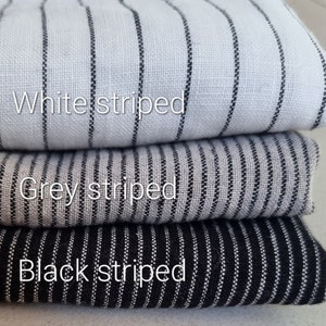 May include: Three fabric swatches stacked on top of each other. The top swatch is white with black stripes, the middle swatch is gray with black stripes, and the bottom swatch is black with white stripes.