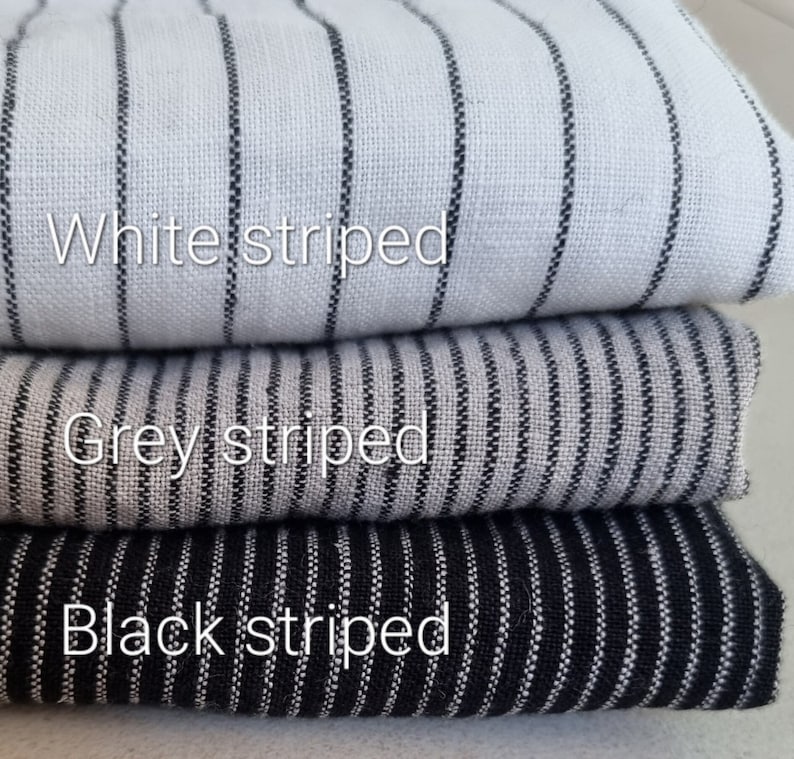May include: Three fabric swatches stacked on top of each other. The top swatch is white with black stripes, the middle swatch is gray with black stripes, and the bottom swatch is black with white stripes.