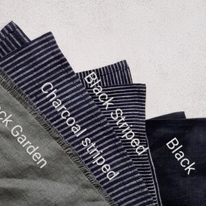 May include: Four fabric swatches in different colors and patterns. The swatches are labeled "Rock Garden", "Charcoal striped", "Black striped", and "Black".