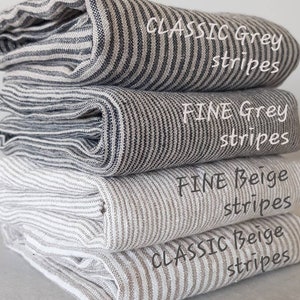 May include: Four different striped fabric swatches stacked on top of each other. The top swatch is a classic grey stripe, the second is a fine grey stripe, the third is a fine beige stripe, and the bottom swatch is a classic beige stripe.
