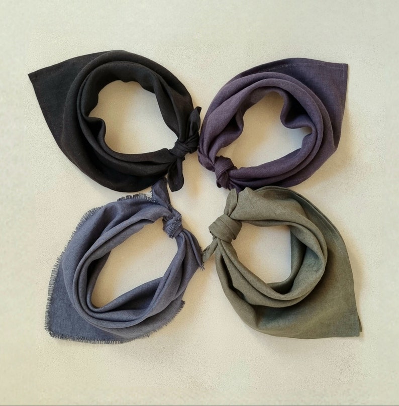 May include: Four fabric bandanas in different shades of blue and green. The bandanas are folded and arranged in a circle, with the points of each bandana meeting in the center.