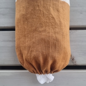 May include: A brown and white linen bag with a drawstring closure. The bag is made of a natural fabric and has a rustic look.