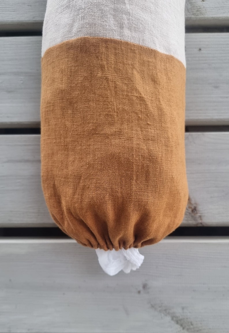 May include: A brown and white linen bag with a drawstring closure. The bag is made of a natural fabric and has a rustic look.
