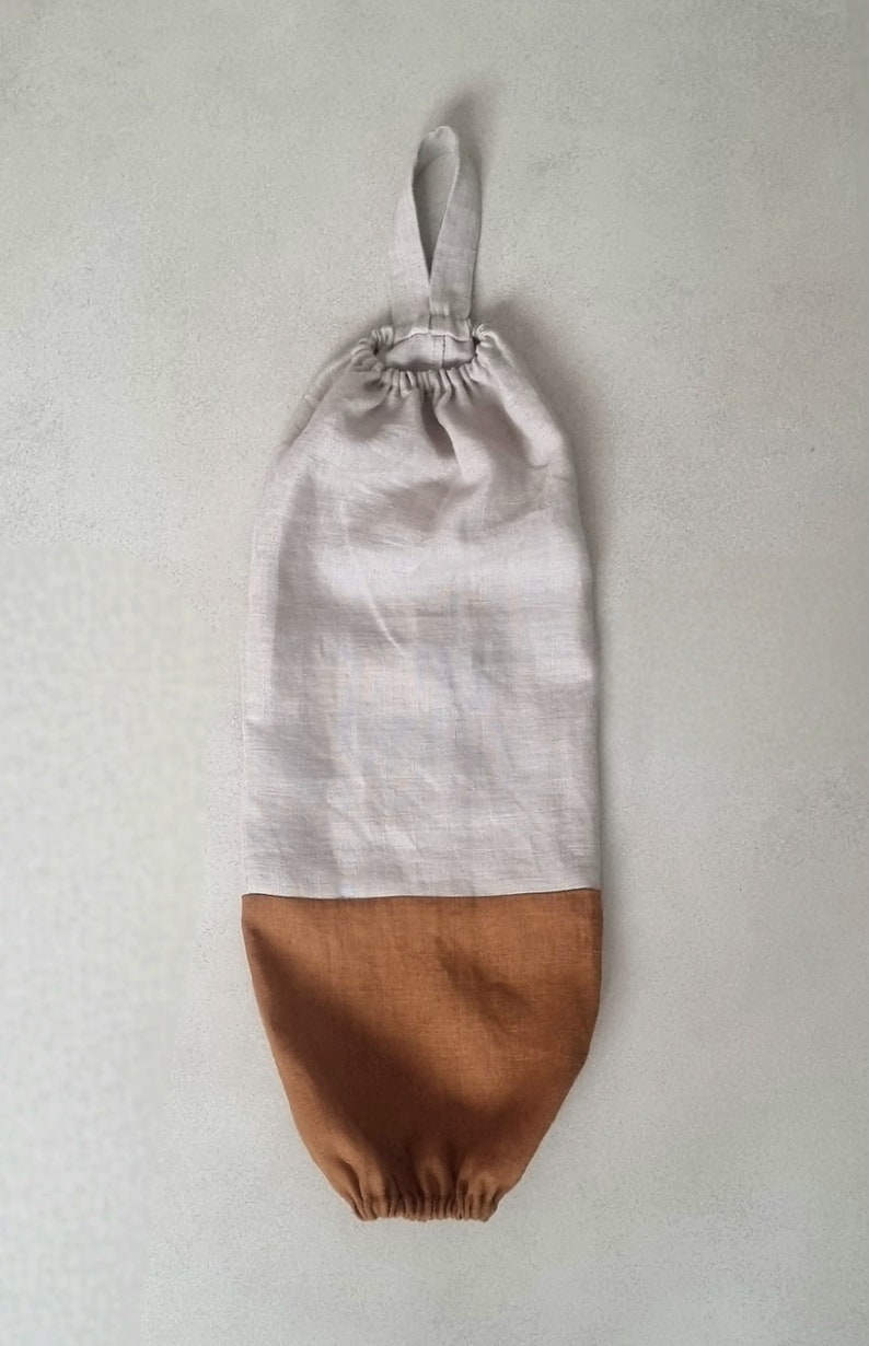 May include: A beige and brown linen reusable grocery bag with a single loop handle.