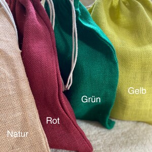 May include: Four drawstring bags made of natural fabric in different colors: natural, red, green, and yellow. The bags are labeled with the colors "Natur", "Rot", "Gr&uuml;n", and "Gelb".